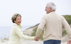 fit older couple walking on beach east gippsland osteopathy