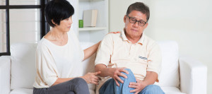 what is osteoarthritis picture of older couple on sofa, one with knee pain