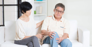 picture of older couple on sofa one with knee pain