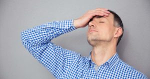 man experiencing migraine or tension headache