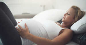 pregnancy and pelvic pain woman lying on bed